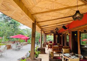 MakindyeThe Forest Resort - Lweza的木制屋顶下带桌椅的天井