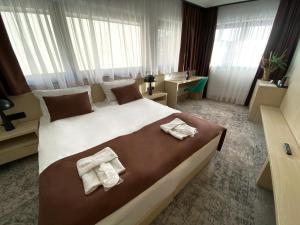 萨拉热窝Hotel Boss的酒店客房带一张大床,带毛巾