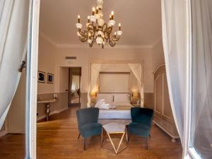圣玛格丽塔-利古雷圣安德烈亚酒店的配有一张床、两把椅子和吊灯的房间