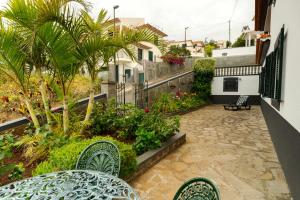 丰沙尔Charming Apartments in Funchal - São Gonçalo的阳台配有桌椅和植物