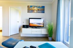 库克斯港Beach Lodge BL03的客厅配有白色橱柜上的平面电视