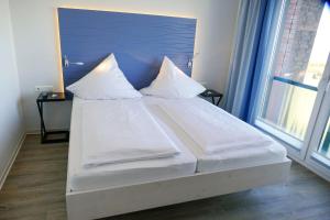 库克斯港Beach Lodge BL03的一张带白色床单和枕头的床