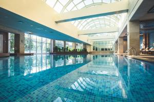 贝莱克Rixos Premium Belek - The Land of Legends Access的一座带玻璃天花板的建筑中的游泳池