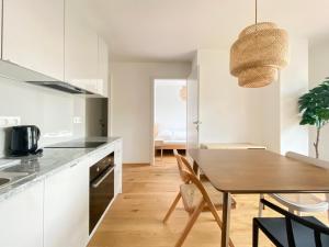 维也纳STAD10 - Apartments very close to subway U2 Stadlau的厨房以及带木桌的用餐室。