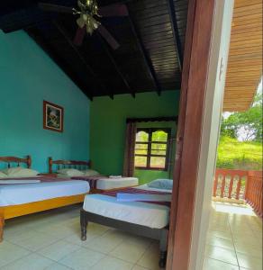 科潘玛雅遗址Hotel Rosalila的一间设有三张床的卧室,位于带绿色墙壁的房间