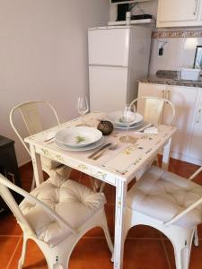 马尔旺A Casa Pequenina - Escusa, Marvão的一张带椅子和盘子的白色桌子以及酒杯