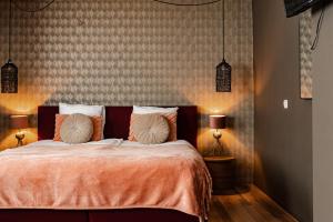 法尔肯堡Hotel La Casa的一间卧室配有一张带橙色床单和两盏灯的床。