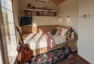 Jugureni1001 Village的一间卧室配有一张床和吉他
