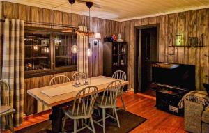 斯朱森Gorgeous Home In Sjusjen With Wifi的一间带桌椅和电视的用餐室