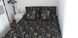 兰卡特Apartament z widokiem Łańcut的一张带黑色花卉床罩和枕头的床