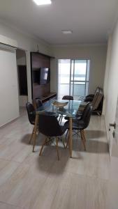 大普拉亚Apartamento Praia Grande -Canto do Forte的一间设有玻璃桌和椅子的用餐室