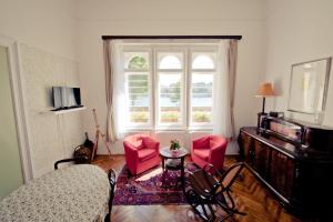 布达佩斯布达弗莱特公寓的客厅设有红色椅子和窗户