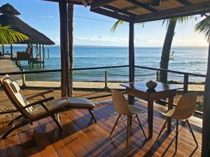 博卡斯德尔托罗Casa Cayuco Eco-Adventure Lodge的一个带桌椅的庭院和大海