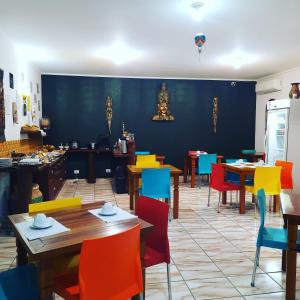 圣塞巴斯蒂安Pousada Estrela Mare的用餐室配有桌子和五颜六色的椅子
