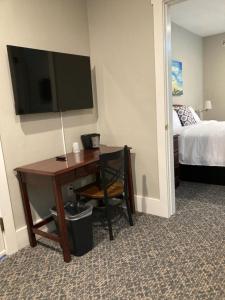 新荷兰Country Squire Inn and Suites的酒店客房配有一张书桌、一台电视和一张床