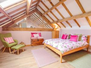 艾尔斯伯里Yew Tree Farm的阁楼卧室配有床和椅子