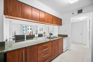 迈阿密Luxurious 1 Bed Apartment in Brickell • Ocean View的厨房配有木制橱柜和台面