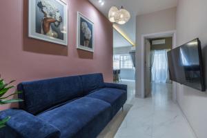 森格莱阿New & unique apartment - A 5 minutes ferry to capital city of Valletta的客厅配有蓝色的沙发和电视