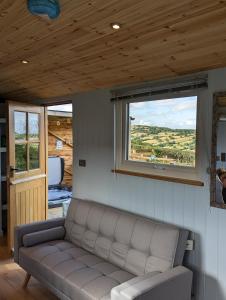 LlanveynoeBespoke luxury huts with hot tubs. Located in the black mountains.的带沙发和窗户的客厅