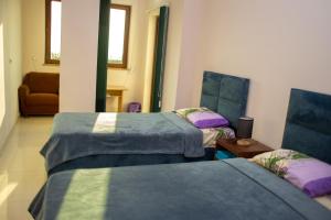 埃里温Apex rest house的客房设有两张床、一张桌子和一张沙发。