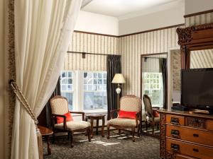 维多利亚朋德莱茶屋酒店的客厅配有椅子、电视和镜子