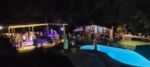 Petreto-BicchisanoGites San Austinu的一群人晚上站在游泳池旁