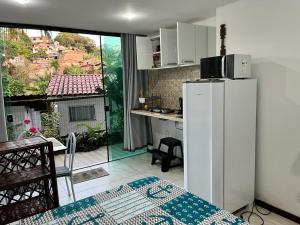 莫罗圣保罗Flat Rosebahia的美景厨房配有冰箱和桌子
