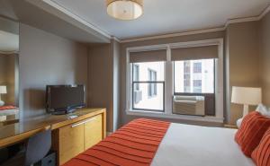 西雅图麦克斯酒店的一间卧室设有一张床、一台电视和一个窗口。