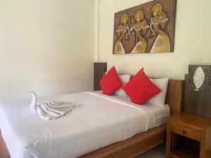 乌布恩迪拉扑拉塞特2简易别墅的一间卧室配有一张带红色枕头的床和天鹅