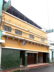 危地马拉Hotel Landivar Zona 7的黄色的建筑,旁边标有标志