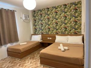 达沃市红色骑士花园酒店的小房间设有两张床和壁纸