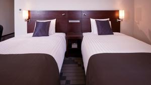 横滨JR-East Hotel Mets Yokohama Tsurumi的配有白色床单的酒店客房内的两张床