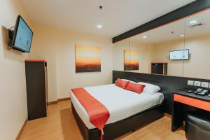 新加坡Hotel 81 Heritage的一间卧室配有一张床、一张书桌和一台电视