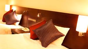 横滨JR-East Hotel Mets Yokohama Tsurumi的酒店客房,配有一张带枕头的床