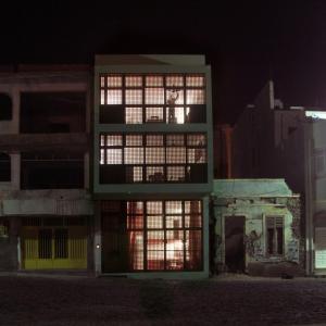 明德卢Paz Apartment的一座晚上有很多窗户的建筑