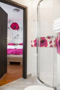 比亚韦斯托克马戈别墅旅舍的一间带玻璃淋浴的浴室和一张床