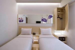 泗水Cleo Tunjungan的紫色小客房内的两张床