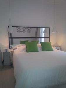 里斯本哥斯达城堡公寓的卧室配有带绿色枕头的大型白色床