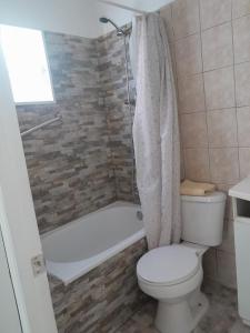巴伊亚英格莱萨Cabanas bahia inglesa的浴室配有卫生间和带浴缸的淋浴。