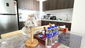 哥打巴鲁GOLDEN TROIKA KOTA BHARU - 2 bedrooms的厨房配有带水瓶的桌子