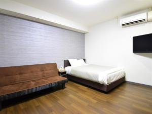 冈山Regariain - Vacation STAY 85013的一间卧室配有一张床和一张沙发