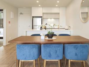 奥克兰Luxurious 2 bedroom apartment Free secure parking的厨房配有木桌和蓝色椅子