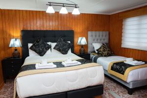 威廉斯港Hotel Forjadores del Cabo de Hornos的木镶板客房内的两张床