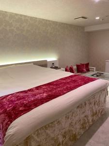 名古屋丽晶酒店（仅限成人）的一间卧室配有一张带红色毯子的大床