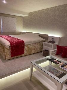 名古屋丽晶酒店（仅限成人）的一间卧室配有一张床和一张茶几