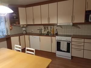 拉彭兰塔Saimaa home的厨房配有白色橱柜、水槽和桌子