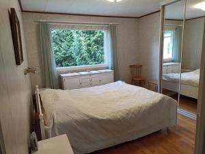 拉彭兰塔Saimaa home的一间卧室设有一张床、一个窗口和一面镜子