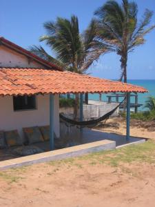 皮帕Casa do amor的一个带吊床、棕榈树和大海的度假胜地