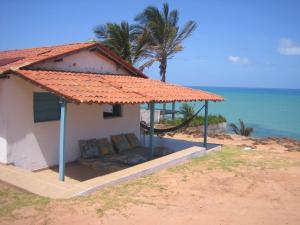 皮帕Casa do amor的海滩上的房子,在伞下配有沙发
