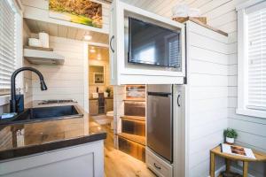 Apple ValleyDelightful tiny home conveniently located的一个带水槽的厨房和墙上的电视